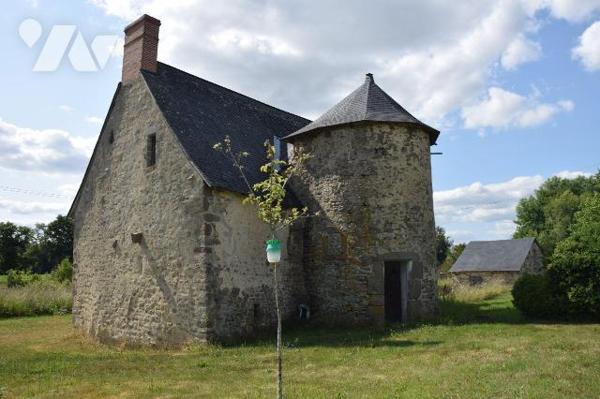 JUBLAINS- En campagne, propriété comprenant une maison de maître en pierres à rénover et ses dé...