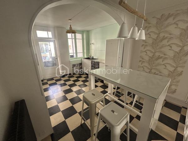 Découvrez cette agréable maison de ville offrant de beaux volumes et un fort potentiel, idéale pour une famille ou un projet d'investissement. 
Au rez-de-chaussée, vous serez accueilli par une véranda lumineuse desservant une cuisine conviviale ainsi qu'une salle à manger chaleureuse. 
Le premier étage se compose d'un salon confortable, d'une chambre ainsi que d'une salle de bains avec toilettes. 
Au deuxième étage, l'espace nuit propose deux chambres supplémentaires et un cabinet de toilettes. 
A l'extérieur, vous profiterez d'une première cour menant à une dépendance d'environ 19 m². Un jardin dessert deux garages dont l'un est actuellement loué, offrant ainsi un revenu locatif complémentaire. Les garages bénéficient d'un accès sur une autre rue, un véritable atout en termes de praticité. 
Cette maison pleine de charme saura séduire les acquéreurs à la recherche d'un bien fonctionnel avec des possibilités d'aménagement.