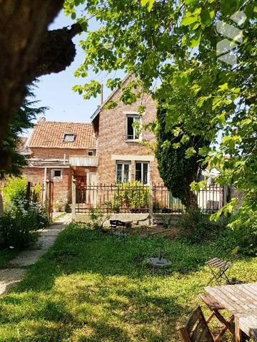 Maison de caractère de 125 m² habitable bâtie sur 1171 m² avec jardin, 2 garages et parking.