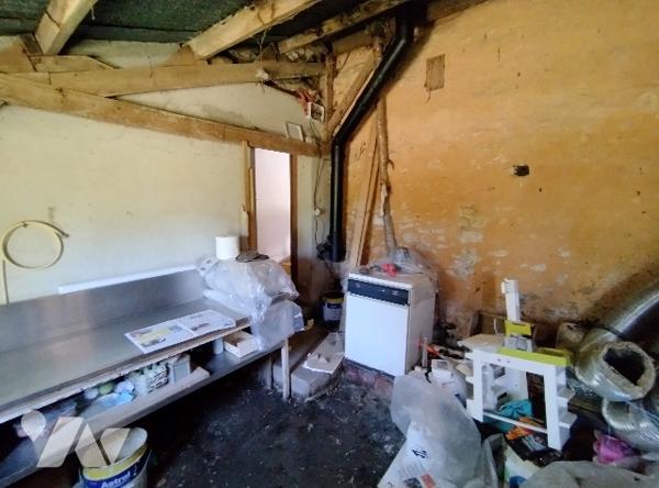 Maison à rénover : cuisine, salle de bains avec WC, séjour avec poêle, bibliothèque, WC, 2 chambres