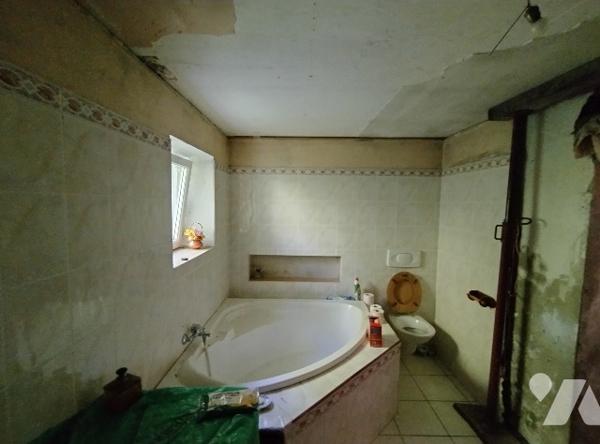 Maison à rénover : cuisine, salle de bains avec WC, séjour avec poêle, bibliothèque, WC, 2 chambres