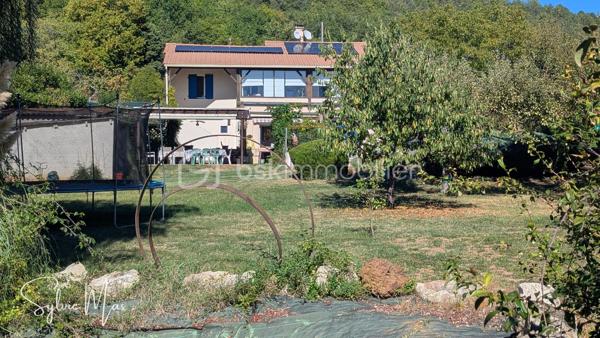 Réf. Océane - À Fumel, au bout d’une allée, découvrez cette maison implantée dans un environnement verdoyant sur une parcelle arborée de 3 591 m².
Ici, les extérieurs constituent un véritable espace de vie : arbres fruitiers, pergola, cuisine d’été, salon d’été et piscine couverte de 5 x 10 m avec tunnel permettent de profiter pleinement du jardin et de recevoir dans un cadre agréable et paisible.

Construite sur sous-sol, la maison développe environ 122 m² habitables et bénéficie d’équipements visant à maîtriser les consommations : panneaux photovoltaïques en autoconsommation avec batterie virtuelle, pompe à chaleur air/eau, chauffage au sol partiel, insert et alimentation en eau par un puits.
Au niveau principal, vous trouverez une véranda d’environ 20 m² offrant une jolie vue sur le jardin, une pièce de vie chaleureuse composée d’un salon avec insert, d’une salle à manger et d’une cuisine ouverte. Ce niveau comprend également une chambre avec dressing, un bureau, une salle d’eau avec douche à l’italienne et double vasque, un WC indépendant ainsi qu’une mezzanine pouvant accueillir une chambre supplémentaire.

Le rez-de-chaussée / sous-sol aménagé offre des espaces particulièrement appréciables pour recevoir : un salon ou bureau, un dortoir d’environ 26 m², une buanderie, une douche, un WC ainsi qu’un garage d’environ 37 m².
À l’extérieur : cuisine d’été, salon d’été, local jardin, carport et plusieurs possibilités de stationnement.
Deux portails et des allées goudronnées facilitent la circulation autour de la propriété. La maison dispose également de gouttières aluminium récentes, d’un adoucisseur d’eau et d’une toiture en très bon état.

Une propriété pensée pour profiter pleinement des espaces extérieurs, recevoir, jardiner et développer différents projets, tout en bénéficiant d’équipements favorisant une meilleure autonomie énergétique.