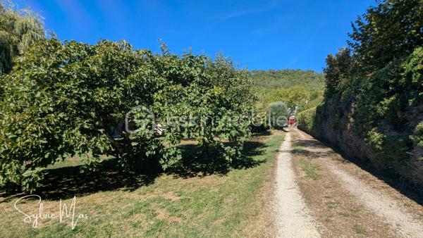 Réf. Océane - À Fumel, au bout d’une allée, découvrez cette maison implantée dans un environnement verdoyant sur une parcelle arborée de 3 591 m².
Ici, les extérieurs constituent un véritable espace de vie : arbres fruitiers, pergola, cuisine d’été, salon d’été et piscine couverte de 5 x 10 m avec tunnel permettent de profiter pleinement du jardin et de recevoir dans un cadre agréable et paisible.

Construite sur sous-sol, la maison développe environ 122 m² habitables et bénéficie d’équipements visant à maîtriser les consommations : panneaux photovoltaïques en autoconsommation avec batterie virtuelle, pompe à chaleur air/eau, chauffage au sol partiel, insert et alimentation en eau par un puits.
Au niveau principal, vous trouverez une véranda d’environ 20 m² offrant une jolie vue sur le jardin, une pièce de vie chaleureuse composée d’un salon avec insert, d’une salle à manger et d’une cuisine ouverte. Ce niveau comprend également une chambre avec dressing, un bureau, une salle d’eau avec douche à l’italienne et double vasque, un WC indépendant ainsi qu’une mezzanine pouvant accueillir une chambre supplémentaire.

Le rez-de-chaussée / sous-sol aménagé offre des espaces particulièrement appréciables pour recevoir : un salon ou bureau, un dortoir d’environ 26 m², une buanderie, une douche, un WC ainsi qu’un garage d’environ 37 m².
À l’extérieur : cuisine d’été, salon d’été, local jardin, carport et plusieurs possibilités de stationnement.
Deux portails et des allées goudronnées facilitent la circulation autour de la propriété. La maison dispose également de gouttières aluminium récentes, d’un adoucisseur d’eau et d’une toiture en très bon état.

Une propriété pensée pour profiter pleinement des espaces extérieurs, recevoir, jardiner et développer différents projets, tout en bénéficiant d’équipements favorisant une meilleure autonomie énergétique.