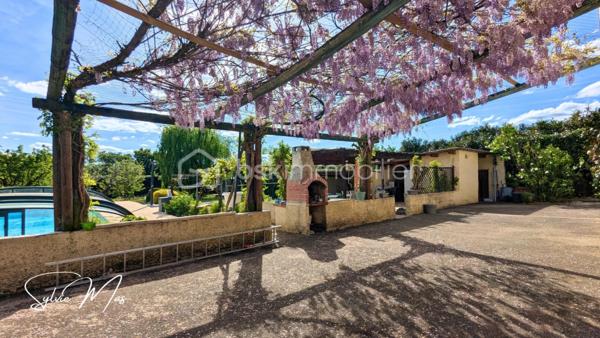 Réf. Océane – À Fumel, au bout d'une allée se dresse une maison accueillante sur deux niveaux. Ici, l’extérieur n’est pas un simple jardin : c’est un véritable espace de vie à part entière de 3 591 m2 arborés. Ici, tout a été pensé pour conjuguer qualité de vie et autonomie énergétique : maison alimentée par un puits, panneaux solaires en autoconsommation avec batterie virtuelle, pompe à chaleur air/eau, chauffage au sol partiel, insert… Autant d'équipements qui participent à réduire les coûts énergétiques.
Arbres fruitiers, pergola, cuisine d’été, salon d’été, piscine couverte 5 x 10 m avec tunnel… chaque espace invite à la détente, recevoir ou simplement profiter d’un cadre de vie paisible avec une jolie vue sur le jardin et l’horizon depuis la véranda.

La maison, construite sur sous-sol, développe environ 122 m² habitables et offre une organisation chaleureuse et fonctionnelle :
Au niveau principal : une véranda d’environ 20 m² surplombant le jardin, une agréable pièce de vie avec salon et insert, salle à manger et cuisine ouverte d’environ 30 m², une chambre avec dressing, un bureau, une salle d’eau avec douche italienne, double vasque, WC indépendant, une mezzanine pouvant accueillir un espace bureau, lecture ou couchage d’appoint...
En rez-de-chaussée / sous-sol aménagé parfait pour recevoir : un salon supplémentaire ou bureau, un dortoir d’environ 26 m², une buanderie, douche et WC ainsi qu'un garage d’environ 37 m². 

À l’extérieur : cuisine d’été, salon d’été, local jardin, local technique sous piscine.
Deux portails permettant une circulation pratique autour de la propriété, allées goudronnées, carports et stationnements, gouttières aluminium récentes, toiture en très bon état, adoucisseur d'eau.

Un lieu idéal pour ceux qui recherchent davantage qu’une maison : un environnement de vie où l’on peut recevoir, jardiner, profiter et imaginer de nombreux projets.
À découvrir sans tarder.