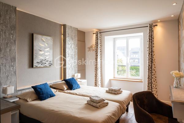 RARE À LA VENTE – Magnifique appartement T3 en plein cœur historique de Dinan
Venez découvrir sans tarder ce superbe appartement T3 situé au 2ᵉ étage d'un petit immeuble idéalement placé sur la place de l'église Saint-Sauveur, récemment réaménagée.
Son emplacement exceptionnel vous permettra de profiter pleinement du centre historique de Dinan, tout en bénéficiant de la proximité immédiate du grand parking souterrain.
L'appartement se compose de deux belles chambres avec placards intégrés, dont une disposant d'une élégante salle d'eau avec douche. Vous trouverez également un WC indépendant ainsi qu'un vaste espace de vie lumineux comprenant un salon-séjour ouvert sur une cuisine entièrement équipée, aménagée avec des matériaux de qualité et des prestations haut de gamme.
Un agréable balcon vient compléter cet espace de vie, offrant un véritable coin de détente en plein centre-ville.
Ce bien dispose également d'une cave, d'un grenier ainsi que d'un jardin privatif, un atout particulièrement rare en plein cœur de Dinan.
Un appartement de caractère alliant charme, confort et emplacement privilégié. Une opportunité exceptionnelle à ne pas manquer !