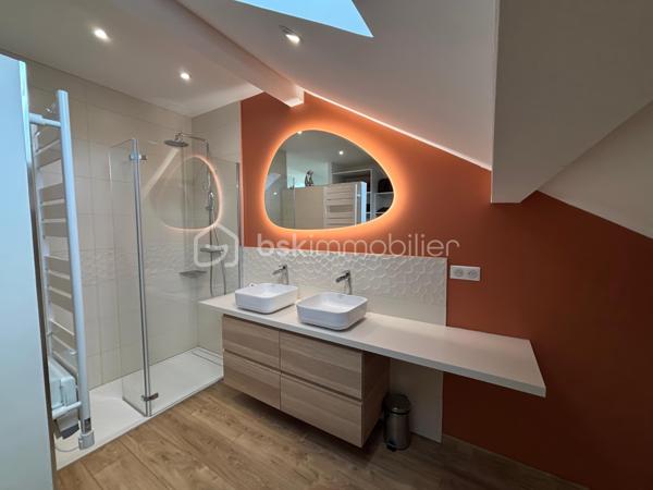 Au cœur du Village du Golf à Idron, découvrez cette maison récente au design contemporain, construite en 2023, développant environ 110 m², avec jardin-terrasse de 33 m² et deux places de stationnement.
Dès l’entrée, le soin apporté aux aménagements se remarque : matériaux de qualité, lignes épurées, association du bois et des teintes naturelles, verrières et équipements soigneusement sélectionnés créent une atmosphère moderne et chaleureuse.
La pièce de vie d’environ 30 m² réunit salon, séjour et cuisine ouverte entièrement équipée, avec un accès direct à la terrasse couverte et au jardin.
Le rez-de-chaussée accueille également une chambre de 10,20 m², une salle de bain et un WC indépendant. 
Il réserve surtout une configuration originale avec une chambre en duplex de 24,40 m², composée d’un bureau de 10,20 m² au niveau inférieur et d’un espace nuit de 14,20 m² à l’étage. Une pièce technique indépendante complète l’ensemble.
À l’étage, la suite parentale de 26 m² constitue l’un des points forts de la maison : chambre, bureau-dressing et salle d’eau avec douche à l’italienne et double vasque. Les volumes sous pente, la verrière et la lumière naturelle donnent à cet espace beaucoup de caractère.
Construite selon la RT 2012, la maison bénéficie d’une climatisation réversible dans toutes les pièces et d’une excellente performance énergétique : DPE A / GES A.
Les vélux sont motorisés et occultants et les volets roulants également l'ensemble est relié à une application domotique.
À l’extérieur, 33 m² de jardin et terrasse couverte prolongent agréablement l’espace de vie.
L’emplacement complète les prestations : golf accessible à pied, site TotalEnergies de Pau à environ 5 minutes, Auchan à 8 minutes et centre-ville de Pau à 10 minutes.
Une maison récente qui se distingue par son design, la qualité de ses aménagements, ses performances énergétiques et une situation particulièrement pratique aux portes de Pau.