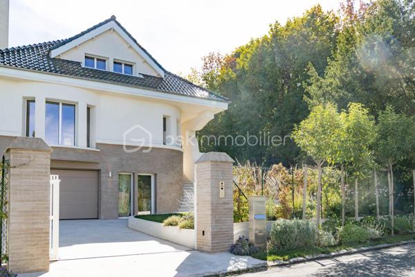 Au sein du prestigieux Domaine de Grand Champ, dans un environnement résidentiel privilégié à proximité immédiate de Saint-Germain-en-Laye, cette maison d'architecte entièrement rénovée en 2024 développe 201 m² habitables sur un magnifique terrain arboré de 1 265 m².

Dès l'entrée, les volumes généreux, la luminosité et la qualité des prestations séduisent immédiatement. Le rez-de-chaussée accueille un vaste séjour et une salle à manger traversants, ouverts sur le jardin par une élégante façade vitrée aux lignes courbes. La cuisine, aménagée sur mesure, indépendante tout en restant ouverte sur les espaces de vie, est équipée d'un îlot central en granit et de plans de travail en Corian. Elle se prolonge naturellement vers une agréable terrasse de 30 m². Un bureau bénéficiant d'une vue sur le jardin, un vestiaire et un WC invités complètent ce niveau.

À l'étage, l'espace nuit se compose de deux chambres avec placards intégrés. La première bénéficie d'une spacieuse salle d'eau avec WC. La seconde dispose également de sa propre salle d'eau avec WC. Les deux chambres s'organisent autour d'un dressing central réalisé sur mesure.

Le rez-de-jardin, accessible de plain-pied et bénéficiant d'une entrée indépendante, constitue un véritable espace de vie complémentaire. Il comprend un salon télévision, cinéma ou bibliothèque bénéficiant d'une isolation acoustique renforcée, deux chambres supplémentaires avec placards, une salle d'eau avec WC, une kitchenette ainsi qu'une buanderie aménagée et équipée.

Un studio indépendant entièrement équipé complète l'ensemble et offre de nombreuses possibilités : accueil de la famille, activité professionnelle, hébergement d'amis ou logement autonome.

La rénovation a été réalisée avec une attention particulière portée au confort et à la performance énergétique : isolation complète, menuiseries aluminium à profilés fins, ventilation double flux thermodynamique assurant chauffage et rafraîchissement, rangements sur mesure et équipements récents. La maison est classée DPE C et bénéficie des garanties décennales liées aux travaux réalisés.

Garage motorisé, stationnements extérieurs et portail automatique viennent parfaire les prestations. 

Une propriété rare, alliant architecture, confort contemporain et qualité de vie, au cœur de l'un des secteurs les plus recherchés de l'Ouest parisien.