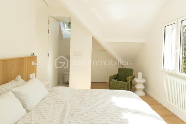 Au sein du prestigieux Domaine de Grand Champ, dans un environnement résidentiel privilégié à proximité immédiate de Saint-Germain-en-Laye, cette maison d'architecte entièrement rénovée en 2024 développe 201 m² habitables sur un magnifique terrain arboré de 1 265 m².

Dès l'entrée, les volumes généreux, la luminosité et la qualité des prestations séduisent immédiatement. Le rez-de-chaussée accueille un vaste séjour et une salle à manger traversants, ouverts sur le jardin par une élégante façade vitrée aux lignes courbes. La cuisine, aménagée sur mesure, indépendante tout en restant ouverte sur les espaces de vie, est équipée d'un îlot central en granit et de plans de travail en Corian. Elle se prolonge naturellement vers une agréable terrasse de 30 m². Un bureau bénéficiant d'une vue sur le jardin, un vestiaire et un WC invités complètent ce niveau.

À l'étage, l'espace nuit se compose de deux chambres avec placards intégrés. La première bénéficie d'une spacieuse salle d'eau avec WC. La seconde dispose également de sa propre salle d'eau avec WC. Les deux chambres s'organisent autour d'un dressing central réalisé sur mesure.

Le rez-de-jardin, accessible de plain-pied et bénéficiant d'une entrée indépendante, constitue un véritable espace de vie complémentaire. Il comprend un salon télévision, cinéma ou bibliothèque bénéficiant d'une isolation acoustique renforcée, deux chambres supplémentaires avec placards, une salle d'eau avec WC, une kitchenette ainsi qu'une buanderie aménagée et équipée.

Un studio indépendant entièrement équipé complète l'ensemble et offre de nombreuses possibilités : accueil de la famille, activité professionnelle, hébergement d'amis ou logement autonome.

La rénovation a été réalisée avec une attention particulière portée au confort et à la performance énergétique : isolation complète, menuiseries aluminium à profilés fins, ventilation double flux thermodynamique assurant chauffage et rafraîchissement, rangements sur mesure et équipements récents. La maison est classée DPE C et bénéficie des garanties décennales liées aux travaux réalisés.

Garage motorisé, stationnements extérieurs et portail automatique viennent parfaire les prestations. 

Une propriété rare, alliant architecture, confort contemporain et qualité de vie, au cœur de l'un des secteurs les plus recherchés de l'Ouest parisien.