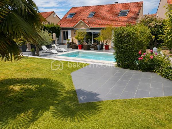 Dans un environnement résidentiel recherché, au calme et à l’abri des regards, cette élégante maison individuelle de 146 m² offre un cadre de vie privilégié.

Dès l’entrée, la maison dévoile une superbe pièce de vie de 47 m², sublimée par une cheminée et de larges baies vitrées ouvrant sur une vaste terrasse. 

Les espaces de vie profitent d’une luminosité remarquable et d’une vue dégagée sur le jardin paysager et la piscine, créant une atmosphère raffinée et apaisante.

Édifiée sur un terrain arboré de 885 m², la propriété bénéficie d’aménagements extérieurs pensés comme un véritable espace de détente : grande terrasse, piscine parfaitement intégrée, jacuzzi et jardin soigneusement entretenu.

Le rez-de-chaussée propose :

•	une cuisine indépendante de 18 m², fonctionnelle et conviviale, 
•	une suite parentale, 
•	une seconde chambre avec accès direct à la terrasse et à la piscine,
•	une salle de bain indépendante, 
•	un WC séparé, 
•	un cellier, 
•	ainsi qu’un garage. 

À l’étage, un vaste palier dessert :

•	deux chambres supplémentaires dont une seconde suite parentale, 
•	et un WC indépendant. 

Deux places de stationnement complètent l’ensemble.

La maison bénéficie également d’un emplacement idéal, proche des écoles, des commodités et de la gare permettant de rejoindre Paris facilement, tout en offrant un accès rapide à l’aéroport Roissy Charles-de-Gaulle.

Cette propriété séduit par son harmonie entre confort familial et prestations de qualité, dans un esprit chaleureux où chaque espace a été pensé pour profiter pleinement de l’intérieur comme de l’extérieur.

Un bien rare offrant une qualité de vie exceptionnelle.