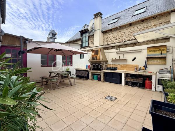 Au cœur de Lamballe, profitez d'un mode de vie privilégié où tout se fait à pied.

Située à seulement 3 minutes du centre-ville, à moins de 10 minutes à pied de la gare, cette maison de caractère bénéficie également d'un accès rapide aux axes menant vers les plages de la côte bretonne.

Derrière sa façade discrète se dévoile une maison atypique aux volumes généreux développant environ 170 m² habitables, où le charme de l'ancien se mêle à une vie citadine particulièrement confortable.

Dès l'entrée, vous découvrirez une agréable pièce de vie chaleureuse agrémentée d'une cheminée avec insert, idéale pour les soirées d'hiver, ainsi qu'une cuisine aménagée et équipée ouvrant sur un véritable atout rare en cœur de ville : un vaste patio d'environ 35 m².
Véritable pièce de vie extérieure, cet espace intimiste permet de profiter pleinement des beaux jours, d'organiser des repas en famille ou entre amis et de savourer les plaisirs de l'extérieur sans les contraintes d'entretien d'un jardin.

Le premier étage accueille trois chambres de belles dimensions ainsi qu'une salle d'eau avec WC.

Au second niveau, un salon cocooning sous les toits, une vaste quatrième chambre avec sa salle de bains privative, un WC indépendant ainsi qu'une mezzanine composent un espace idéal pour une suite parentale, un adolescent en quête d'indépendance ou encore un espace dédié au télétravail.

La maison bénéficie d'un chauffage au gaz de ville complété par une cheminée avec insert, offrant confort et convivialité au quotidien.

Elle se distingue également par ses nombreux espaces annexes. Depuis le patio, une charmante porte en ogive donne accès à un local de stockage plein de caractère, idéal pour un atelier, le rangement ou le stockage de matériel. Un passage couvert dessert également le patio et facilite le stationnement des vélos, poussettes ou équipements du quotidien, un avantage particulièrement appréciable en centre-ville.

Enfin, un garage d'environ 18 m² avec porte motorisée complète l'ensemble et apporte un confort devenu rare pour une maison située en plein cœur de Lamballe.

Quelques rafraîchissements décoratifs permettront aux futurs propriétaires de révéler tout le potentiel de cette maison et de la personnaliser à leur image afin d'en faire un véritable cocon familial.

Une adresse idéale pour ceux qui recherchent le charme de l'ancien, de beaux volumes, un extérieur facile à vivre et la praticité d'une vie de centre-ville.
À découvrir sans tarder.