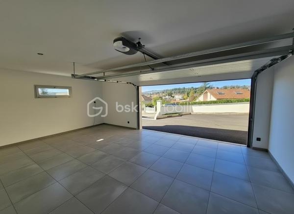 Une réalisation contemporaine confidentielle, pensée dans les moindres détails.
À Villerest, dans un environnement résidentiel particulièrement paisible, cette propriété contemporaine d’environ 185 m² habitables se distingue par son architecture, ses volumes et la qualité de ses prestations.
Achevée en 2023 et implantée sur un terrain d’environ 1 000 m², elle a été conçue autour d’une idée forte : privilégier les volumes, la lumière et la relation entre les espaces intérieurs et extérieurs.
Quelques marches suffisent à rejoindre le niveau principal de la maison, qui se développe ensuite entièrement de plain-pied. Une configuration particulièrement confortable et parfaitement adaptée à une vie familiale comme à une réception élégante.

La pièce maîtresse est sans conteste la pièce de vie de près de 90 m² avec sa cuisine entièrement équipée, espace repas et salon s’y articulent naturellement dans un volume spectaculaire, largement ouvert sur l’extérieur.
Les nombreuses baies vitrées et ouvertures offrent une luminosité exceptionnelle et permettent à la lumière naturelle d’accompagner les différents moments de la journée.
L’espace nuit se compose de trois chambres avec salles de bains privatives, tandis qu’une aile indépendante accueille une véritable suite parentale, composée d’une chambre, d’un grand dressing et d’une salle de bains raffinée avec douche, baignoire et WC.

À l’extérieur, la terrasse exposée sud-ouest prolonge naturellement les espaces de réception. Elle accueille une piscine à débordement et offre une agréable ouverture visuelle sur le lac de Villerest.

La propriété bénéficie également d’équipements à la hauteur de son architecture : grandes baies vitrées, BSO dans la pièce de vie, volets roulants dans les chambres, climatisation réversible, stores bannes, portail coulissant et garage double.

L’ensemble est complété par des extérieurs soigneusement aménagés, une vaste cour d’accueil et un espace végétalisé préservant l’intimité de la propriété.

Un bien rare sur le secteur, destiné à une clientèle à la recherche d’une architecture contemporaine affirmée, de volumes exceptionnels et d’un environnement privilégié.