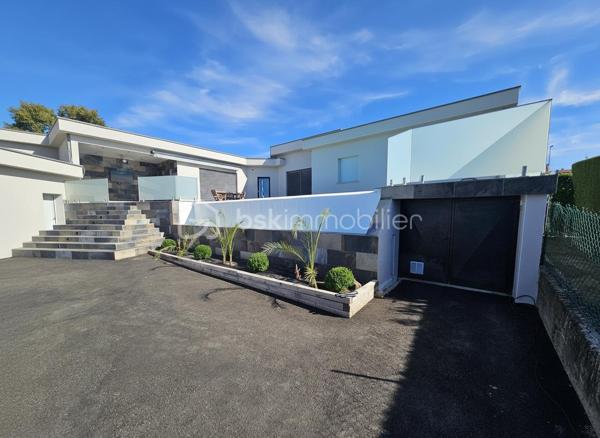Une réalisation contemporaine confidentielle, pensée dans les moindres détails.
À Villerest, dans un environnement résidentiel particulièrement paisible, cette propriété contemporaine d’environ 185 m² habitables se distingue par son architecture, ses volumes et la qualité de ses prestations.
Achevée en 2023 et implantée sur un terrain d’environ 1 000 m², elle a été conçue autour d’une idée forte : privilégier les volumes, la lumière et la relation entre les espaces intérieurs et extérieurs.
Quelques marches suffisent à rejoindre le niveau principal de la maison, qui se développe ensuite entièrement de plain-pied. Une configuration particulièrement confortable et parfaitement adaptée à une vie familiale comme à une réception élégante.

La pièce maîtresse est sans conteste la pièce de vie de près de 90 m² avec sa cuisine entièrement équipée, espace repas et salon s’y articulent naturellement dans un volume spectaculaire, largement ouvert sur l’extérieur.
Les nombreuses baies vitrées et ouvertures offrent une luminosité exceptionnelle et permettent à la lumière naturelle d’accompagner les différents moments de la journée.
L’espace nuit se compose de trois chambres avec salles de bains privatives, tandis qu’une aile indépendante accueille une véritable suite parentale, composée d’une chambre, d’un grand dressing et d’une salle de bains raffinée avec douche, baignoire et WC.

À l’extérieur, la terrasse exposée sud-ouest prolonge naturellement les espaces de réception. Elle accueille une piscine à débordement et offre une agréable ouverture visuelle sur le lac de Villerest.

La propriété bénéficie également d’équipements à la hauteur de son architecture : grandes baies vitrées, BSO dans la pièce de vie, volets roulants dans les chambres, climatisation réversible, stores bannes, portail coulissant et garage double.

L’ensemble est complété par des extérieurs soigneusement aménagés, une vaste cour d’accueil et un espace végétalisé préservant l’intimité de la propriété.

Un bien rare sur le secteur, destiné à une clientèle à la recherche d’une architecture contemporaine affirmée, de volumes exceptionnels et d’un environnement privilégié.
