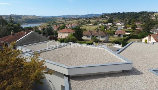 Une réalisation contemporaine confidentielle, pensée dans les moindres détails.
À Villerest, dans un environnement résidentiel particulièrement paisible, cette propriété contemporaine d’environ 185 m² habitables se distingue par son architecture, ses volumes et la qualité de ses prestations.
Achevée en 2023 et implantée sur un terrain d’environ 1 000 m², elle a été conçue autour d’une idée forte : privilégier les volumes, la lumière et la relation entre les espaces intérieurs et extérieurs.
Quelques marches suffisent à rejoindre le niveau principal de la maison, qui se développe ensuite entièrement de plain-pied. Une configuration particulièrement confortable et parfaitement adaptée à une vie familiale comme à une réception élégante.

La pièce maîtresse est sans conteste la pièce de vie de près de 90 m² avec sa cuisine entièrement équipée, espace repas et salon s’y articulent naturellement dans un volume spectaculaire, largement ouvert sur l’extérieur.
Les nombreuses baies vitrées et ouvertures offrent une luminosité exceptionnelle et permettent à la lumière naturelle d’accompagner les différents moments de la journée.
L’espace nuit se compose de trois chambres avec salles de bains privatives, tandis qu’une aile indépendante accueille une véritable suite parentale, composée d’une chambre, d’un grand dressing et d’une salle de bains raffinée avec douche, baignoire et WC.

À l’extérieur, la terrasse exposée sud-ouest prolonge naturellement les espaces de réception. Elle accueille une piscine à débordement et offre une agréable ouverture visuelle sur le lac de Villerest.

La propriété bénéficie également d’équipements à la hauteur de son architecture : grandes baies vitrées, BSO dans la pièce de vie, volets roulants dans les chambres, climatisation réversible, stores bannes, portail coulissant et garage double.

L’ensemble est complété par des extérieurs soigneusement aménagés, une vaste cour d’accueil et un espace végétalisé préservant l’intimité de la propriété.

Un bien rare sur le secteur, destiné à une clientèle à la recherche d’une architecture contemporaine affirmée, de volumes exceptionnels et d’un environnement privilégié.