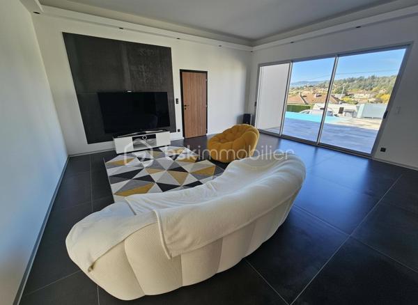 Une réalisation contemporaine confidentielle, pensée dans les moindres détails.
À Villerest, dans un environnement résidentiel particulièrement paisible, cette propriété contemporaine d’environ 185 m² habitables se distingue par son architecture, ses volumes et la qualité de ses prestations.
Achevée en 2023 et implantée sur un terrain d’environ 1 000 m², elle a été conçue autour d’une idée forte : privilégier les volumes, la lumière et la relation entre les espaces intérieurs et extérieurs.
Quelques marches suffisent à rejoindre le niveau principal de la maison, qui se développe ensuite entièrement de plain-pied. Une configuration particulièrement confortable et parfaitement adaptée à une vie familiale comme à une réception élégante.

La pièce maîtresse est sans conteste la pièce de vie de près de 90 m² avec sa cuisine entièrement équipée, espace repas et salon s’y articulent naturellement dans un volume spectaculaire, largement ouvert sur l’extérieur.
Les nombreuses baies vitrées et ouvertures offrent une luminosité exceptionnelle et permettent à la lumière naturelle d’accompagner les différents moments de la journée.
L’espace nuit se compose de trois chambres avec salles de bains privatives, tandis qu’une aile indépendante accueille une véritable suite parentale, composée d’une chambre, d’un grand dressing et d’une salle de bains raffinée avec douche, baignoire et WC.

À l’extérieur, la terrasse exposée sud-ouest prolonge naturellement les espaces de réception. Elle accueille une piscine à débordement et offre une agréable ouverture visuelle sur le lac de Villerest.

La propriété bénéficie également d’équipements à la hauteur de son architecture : grandes baies vitrées, BSO dans la pièce de vie, volets roulants dans les chambres, climatisation réversible, stores bannes, portail coulissant et garage double.

L’ensemble est complété par des extérieurs soigneusement aménagés, une vaste cour d’accueil et un espace végétalisé préservant l’intimité de la propriété.

Un bien rare sur le secteur, destiné à une clientèle à la recherche d’une architecture contemporaine affirmée, de volumes exceptionnels et d’un environnement privilégié.