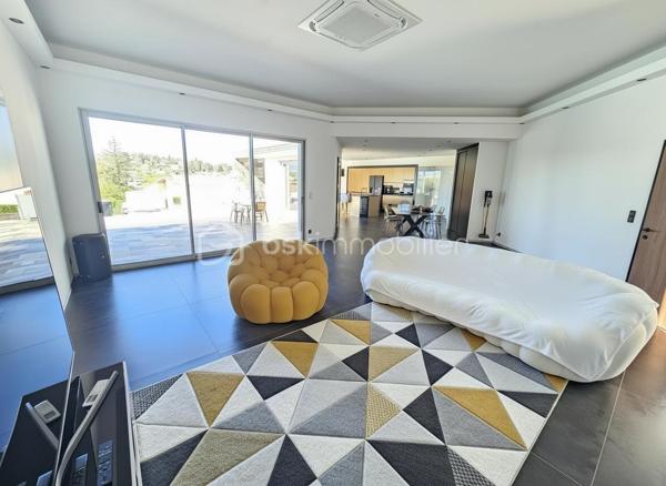 Une réalisation contemporaine confidentielle, pensée dans les moindres détails.
À Villerest, dans un environnement résidentiel particulièrement paisible, cette propriété contemporaine d’environ 185 m² habitables se distingue par son architecture, ses volumes et la qualité de ses prestations.
Achevée en 2023 et implantée sur un terrain d’environ 1 000 m², elle a été conçue autour d’une idée forte : privilégier les volumes, la lumière et la relation entre les espaces intérieurs et extérieurs.
Quelques marches suffisent à rejoindre le niveau principal de la maison, qui se développe ensuite entièrement de plain-pied. Une configuration particulièrement confortable et parfaitement adaptée à une vie familiale comme à une réception élégante.

La pièce maîtresse est sans conteste la pièce de vie de près de 90 m² avec sa cuisine entièrement équipée, espace repas et salon s’y articulent naturellement dans un volume spectaculaire, largement ouvert sur l’extérieur.
Les nombreuses baies vitrées et ouvertures offrent une luminosité exceptionnelle et permettent à la lumière naturelle d’accompagner les différents moments de la journée.
L’espace nuit se compose de trois chambres avec salles de bains privatives, tandis qu’une aile indépendante accueille une véritable suite parentale, composée d’une chambre, d’un grand dressing et d’une salle de bains raffinée avec douche, baignoire et WC.

À l’extérieur, la terrasse exposée sud-ouest prolonge naturellement les espaces de réception. Elle accueille une piscine à débordement et offre une agréable ouverture visuelle sur le lac de Villerest.

La propriété bénéficie également d’équipements à la hauteur de son architecture : grandes baies vitrées, BSO dans la pièce de vie, volets roulants dans les chambres, climatisation réversible, stores bannes, portail coulissant et garage double.

L’ensemble est complété par des extérieurs soigneusement aménagés, une vaste cour d’accueil et un espace végétalisé préservant l’intimité de la propriété.

Un bien rare sur le secteur, destiné à une clientèle à la recherche d’une architecture contemporaine affirmée, de volumes exceptionnels et d’un environnement privilégié.