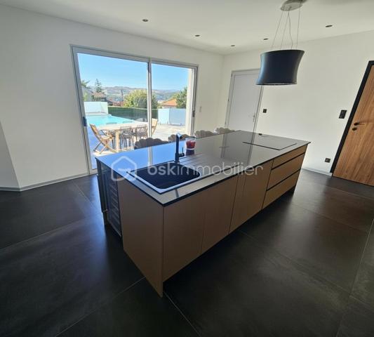 Une réalisation contemporaine confidentielle, pensée dans les moindres détails.
À Villerest, dans un environnement résidentiel particulièrement paisible, cette propriété contemporaine d’environ 185 m² habitables se distingue par son architecture, ses volumes et la qualité de ses prestations.
Achevée en 2023 et implantée sur un terrain d’environ 1 000 m², elle a été conçue autour d’une idée forte : privilégier les volumes, la lumière et la relation entre les espaces intérieurs et extérieurs.
Quelques marches suffisent à rejoindre le niveau principal de la maison, qui se développe ensuite entièrement de plain-pied. Une configuration particulièrement confortable et parfaitement adaptée à une vie familiale comme à une réception élégante.

La pièce maîtresse est sans conteste la pièce de vie de près de 90 m² avec sa cuisine entièrement équipée, espace repas et salon s’y articulent naturellement dans un volume spectaculaire, largement ouvert sur l’extérieur.
Les nombreuses baies vitrées et ouvertures offrent une luminosité exceptionnelle et permettent à la lumière naturelle d’accompagner les différents moments de la journée.
L’espace nuit se compose de trois chambres avec salles de bains privatives, tandis qu’une aile indépendante accueille une véritable suite parentale, composée d’une chambre, d’un grand dressing et d’une salle de bains raffinée avec douche, baignoire et WC.

À l’extérieur, la terrasse exposée sud-ouest prolonge naturellement les espaces de réception. Elle accueille une piscine à débordement et offre une agréable ouverture visuelle sur le lac de Villerest.

La propriété bénéficie également d’équipements à la hauteur de son architecture : grandes baies vitrées, BSO dans la pièce de vie, volets roulants dans les chambres, climatisation réversible, stores bannes, portail coulissant et garage double.

L’ensemble est complété par des extérieurs soigneusement aménagés, une vaste cour d’accueil et un espace végétalisé préservant l’intimité de la propriété.

Un bien rare sur le secteur, destiné à une clientèle à la recherche d’une architecture contemporaine affirmée, de volumes exceptionnels et d’un environnement privilégié.