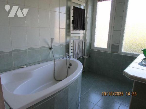 Maison de Caractère située dans un quartier résidentiel, composée de : 
- Au rez-de-chaussée :...