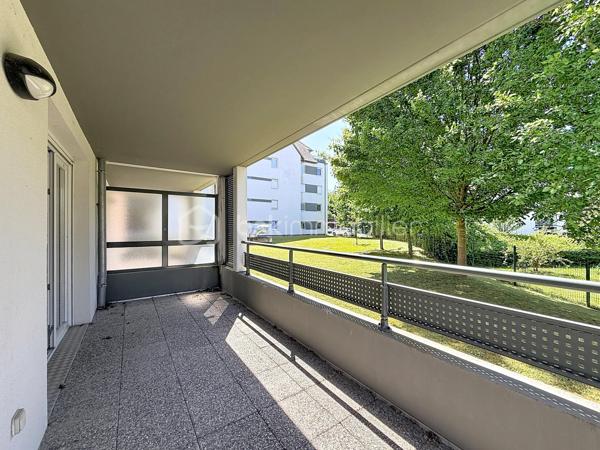 HÉGENHEIM – À deux pas de la Suisse, lumineux 4 pièces avec vaste terrasse, garage et ascenseur

À seulement quelques minutes de Bâle et des principaux axes vers la Suisse, découvrez en exclusivité cet agréable appartement de 84,97 m², situé au sein d'une résidence récente de 2012, parfaitement entretenue.

Dès l'entrée, vous serez séduit par ses volumes généreux et sa belle luminosité. La pièce de vie d'environ 30 m², ouverte sur une cuisine moderne entièrement équipée, offre un espace convivial où il fait bon recevoir famille et amis.

Le véritable atout de cet appartement se révèle à l'extérieur.

Accessible directement depuis le séjour, une spacieuse terrasse couverte, exposée Ouest, prolonge naturellement l'espace de vie. Entièrement située à l'arrière de la résidence, elle bénéficie d'une vue dégagée sur un parc arboré et d'un environnement particulièrement calme, à l'abri des nuisances de la rue. Un véritable espace de détente pour profiter des beaux jours en toute sérénité.

L'espace nuit se compose de trois chambres, d'une salle de bains avec baignoire et fenêtre ainsi que d'un WC indépendant.

Pensé pour offrir un confort de vie au quotidien, l'appartement est accessible aux personnes à mobilité réduite. L'ascenseur dessert également le sous-sol où se trouve le garage fermé, tandis qu'un cellier/cave situé au même niveau que l'appartement apporte un espace de rangement particulièrement pratique.

Les prestations

• Résidence récente (2012)

• 84,97 m² Carrez

• Grande pièce de vie d'environ 30 m²

• Cuisine ouverte entièrement équipée

• 3 chambres

• Terrasse couverte exposée Ouest avec vue sur un parc arboré

• Garage fermé en sous-sol

• Cellier / cave

• Ascenseur

• Accessible PMR

• Fenêtres PVC double vitrage

• Volets roulants électriques

• Porte d'entrée sécurisée

• Interphone

• DPE : C

Un emplacement particulièrement recherché

Hégenheim est une commune très prisée des frontaliers grâce à sa proximité immédiate avec Bâle, les zones d'activités suisses, l'aéroport international et les principaux axes de circulation. Vous profiterez d'un environnement résidentiel agréable tout en restant proche des commerces, des écoles et des services du quotidien.

Un appartement aux prestations actuelles, offrant espace, confort et qualité de vie, idéal pour une famille ou des actifs travaillant en Suisse.