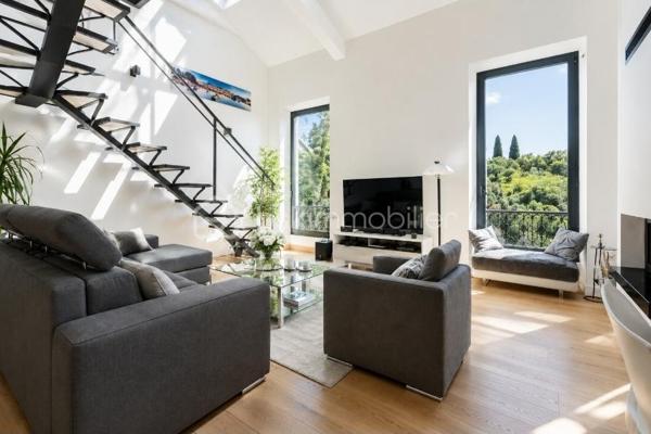 Au sein de la Villa Laetitia, découvrez ce duplex de caractère au 1er étage et dernier étage développant 95,84 m² Loi Carrez complétés par 36,93 m² hors Carrez. Un bien atypique offrant de beaux volumes, une belle luminosité et un véritable esprit maison.

Dès l'entrée, vous serez séduits par la vaste pièce de vie baignée de lumière. La belle hauteur sous plafond, les larges ouvertures, les fenêtres de toit et les vues sur la verdure créent une atmosphère chaleureuse et conviviale. Le séjour, agrémenté d'une cheminée à foyer fermé, s'ouvre sur une cuisine contemporaine avec îlot central, idéale pour partager de beaux moments en famille ou entre amis.

L'agencement a été pensé pour offrir confort et intimité à chacun. Le niveau principal accueille une agréable suite parentale avec sa salle d'eau privative. À l'étage, la mezzanine dessert deux chambres, un espace bureau ainsi qu'une grande salle de bains, créant un espace nuit parfaitement adapté à une vie de famille.

Le bien bénéficie également de deux places de stationnement privatives.

À quelques pas seulement de l'appartement, vous profiterez d'environ 400 m² de terrain privatif aménagé en restanques. Véritable écrin de verdure, cet espace offre de nombreuses possibilités d'aménagement : jardin méditerranéen, potager, espaces de détente ou de loisirs. Sous réserve des autorisations administratives nécessaires, l'installation d'une piscine pourra également être envisagée.

Côté confort, vous bénéficierez d'une climatisation réversible, d'une pompe à chaleur, d'une cheminée à foyer fermé ainsi que de nombreux espaces de rangement.

L'ensemble dégage une véritable personnalité et séduira les acquéreurs à la recherche d'un lieu de vie lumineux, chaleureux et plein de caractère, offrant le confort d'une maison tout en conservant les avantages d'un appartement.

Un bien rare aux volumes généreux, offrant un cadre de vie verdoyant à quelques minutes des commodités et des principaux axes de circulation.