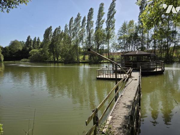 Terrain de loisirs avec plan d'eau d'environ un hectare, en partie arboré.