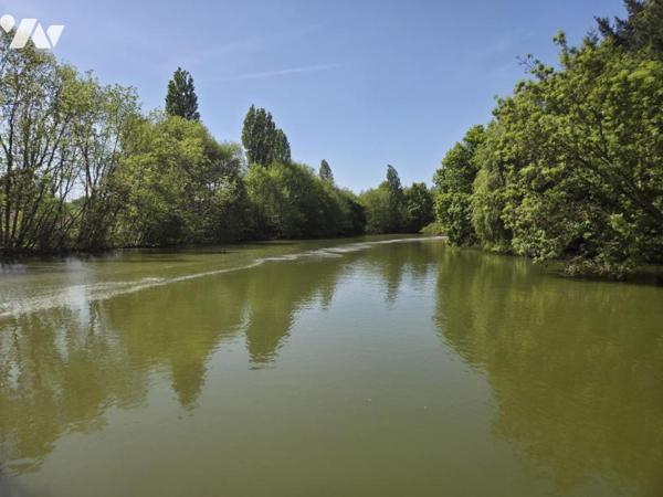 Terrain de loisirs avec plan d'eau d'environ un hectare, en partie arboré.