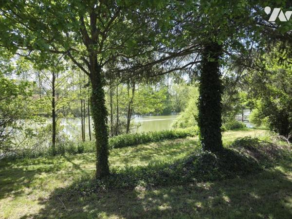 Terrain de loisirs avec plan d'eau d'environ un hectare, en partie arboré.