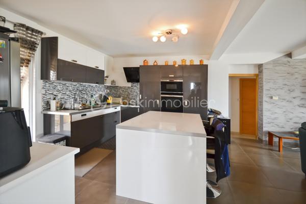 LEDENON

Venez découvrir cette grande villa individuelle au calme avec sa belle vue dégagée. ce bien est répartie sur trois niveaux bénéficie d’un cadre paisible et d’un fort potentiel, permettant la réalisation de nombreux projets : grande maison familiale, gîte, chambres d’hôtes ou encore accueil familial.

Le rez-de-chaussée se compose d’un garage, d’une grande pièce d’accueil / réception avec bar, d’une cuisine, d’une buanderie, de toilettes, d’un dressing, d’une chaufferie ainsi que de plusieurs espaces ateliers.

Au premier étage, vous trouverez une entrée, des toilettes, un cellier, une cuisine équipée et aménagée ouvrant sur une petite terrasse, ainsi qu’un séjour lumineux donnant accès à une belle véranda. Ce niveau comprend également deux chambres, un dressing et une salle d’eau.

Au deuxième étage, un bureau ouvert sur une mezzanine, une grande chambre ainsi qu’une salle d’eau avec toilettes complètent l’ensemble.

Le terrain, arboré et entièrement clôturé, est piscinable. Il dispose de nombreux espaces de stationnement.

Côté prestations techniques, la villa est équipée de panneaux photovoltaïques en autoconsommation avec revente, d’un plancher chauffant réversible ainsi que d’un forage. Pour les moments de détente, un jacuzzi 6 places est installé au rez-de-chaussée.

Une visite s’impose pour découvrir tout le potentiel de ce bien.