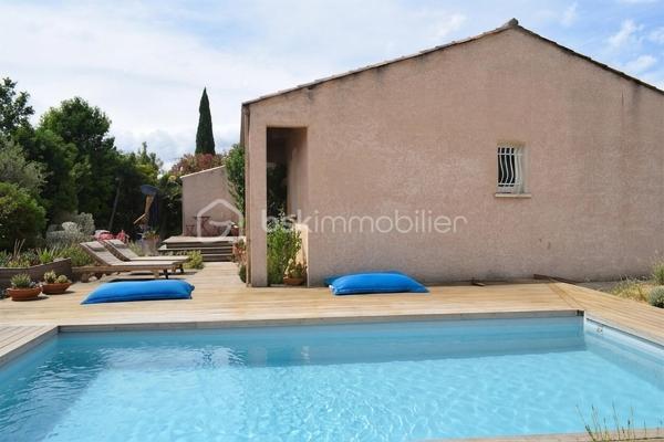 Découvrez cette charmante maison traditionnelle située dans un quartier pavillonnaire paisible de Saint-André-de-Sangonis.
Implantée sur une parcelle de 626 m², cette maison lumineuse de 103 m² environ offre un cadre de vie confortable et fonctionnel, idéal pour une famille à la recherche de tranquillité et d'espace.

Dès l'entrée, vous serez séduits par sa vaste pièce de vie de plus de 43 m², baignée de lumière. Cet espace convivial réunit salon, séjour et cuisine ouverte. La terrasse surélevée, accessible directement depuis la pièce de vie, constitue un véritable prolongement de la maison vers le jardin.

Dans le prolongement du séjour, quelques marches mènent à une pièce supplémentaire bénéficiant d'une baie vitrée et terrasse: Bureau, salon TV, salle de jeux ou quatrième chambre : cet espace s'adapte facilement à tous vos projets.

L'espace nuit se compose de trois chambres avec placard ainsi que d'une salle d'eau fonctionnelle, wc séparé.

Un garage isolé avec mezzanine et accès direct à la maison complète les prestations.

Côté confort, la maison dispose d'une climatisation gainable, de panneaux solaires,chauffe-eau thermodynamique ainsi que d'un adoucisseur d'eau. Eau du canal.

À l'extérieur, vous profiterez d'un agréable jardin arboré agrémenté de lauriers en fleurs, d'une piscine propice aux moments de détente et d'espaces à aménager selon vos envies. Deux portails facilitent l'accès à la propriété et permettent le stationnement de plusieurs véhicules, dont trois voitures sur la parcelle.

Les atouts :
• Maison 4 faces
• Pièce de vie de plus de 43 m²
• Possibilité de créer une 4ème chambre
• Climatisation gainable
• Panneaux solaires
• Piscine
• Garage isolé avec accès direct
• Stationnement multiple
• Terrain de 626 m²

Une maison lumineuse, évolutive et agréable à vivre, offrant un beau potentiel d'aménagement dans un environnement recherché.
Les visuels de home stanging facilitent la projection et permettent d'imaginer le potentiel d'aménagement de ce bien.