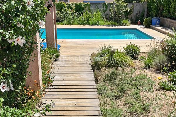 Découvrez cette charmante maison traditionnelle située dans un quartier pavillonnaire paisible de Saint-André-de-Sangonis.
Implantée sur une parcelle de 626 m², cette maison lumineuse de 103 m² environ offre un cadre de vie confortable et fonctionnel, idéal pour une famille à la recherche de tranquillité et d'espace.

Dès l'entrée, vous serez séduits par sa vaste pièce de vie de plus de 43 m², baignée de lumière. Cet espace convivial réunit salon, séjour et cuisine ouverte. La terrasse surélevée, accessible directement depuis la pièce de vie, constitue un véritable prolongement de la maison vers le jardin.

Dans le prolongement du séjour, quelques marches mènent à une pièce supplémentaire bénéficiant d'une baie vitrée et terrasse: Bureau, salon TV, salle de jeux ou quatrième chambre : cet espace s'adapte facilement à tous vos projets.

L'espace nuit se compose de trois chambres avec placard ainsi que d'une salle d'eau fonctionnelle, wc séparé.

Un garage isolé avec mezzanine et accès direct à la maison complète les prestations.

Côté confort, la maison dispose d'une climatisation gainable, de panneaux solaires,chauffe-eau thermodynamique ainsi que d'un adoucisseur d'eau. Eau du canal.

À l'extérieur, vous profiterez d'un agréable jardin arboré agrémenté de lauriers en fleurs, d'une piscine propice aux moments de détente et d'espaces à aménager selon vos envies. Deux portails facilitent l'accès à la propriété et permettent le stationnement de plusieurs véhicules, dont trois voitures sur la parcelle.

Les atouts :
• Maison 4 faces
• Pièce de vie de plus de 43 m²
• Possibilité de créer une 4ème chambre
• Climatisation gainable
• Panneaux solaires
• Piscine
• Garage isolé avec accès direct
• Stationnement multiple
• Terrain de 626 m²

Une maison lumineuse, évolutive et agréable à vivre, offrant un beau potentiel d'aménagement dans un environnement recherché.
Les visuels de home stanging facilitent la projection et permettent d'imaginer le potentiel d'aménagement de ce bien.