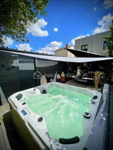 Cette maison contemporaine conçue pour le confort et l'art de vivre vous accueille par une cour pavée, fermée et sécurisée permettant de garer 2 voitures.
Dès l'entrée, découvrez une pièce de vie de 40 m2 intégrant une cuisine aménagée et entièrement équipée, et s'ouvrant sur une véranda-pergola de 17 m2 qui prolonge les espaces intérieurs.
Buanderie fonctionnelle, wc indépendant.
A l'extérieur tout est conçu pour la détente : Une terrasse à l'abri des regards avec un espace SPA, une chambre indépendante de plain-pied avec son coin salle d'eau, et un long jardin paysagé, véritable havre de paix en coeur de ville.
A l'étage, l'espace nuit se distingue par son confort avec 3 chambres disposant chacune de leur salle d'eau privative. wc indépendant.
Un atout rare : un locatif indépendant de 36 m2 en duplex et bénéficiant d'un accès indépendant sur rue, parfait pour revenu locatif immédiat, activité libérale, ou logement pour un proche. Actuellement loué 835€ par mois.
Menuiseries Aluminium, chauffage électrique, nombreux rangements. Parfaitement entretenu, aucuns travaux à prévoir.
Commerces de proximité, marché, bus, nouvelle ligne de tram à quelques minutes à pied. Quartier calme.
