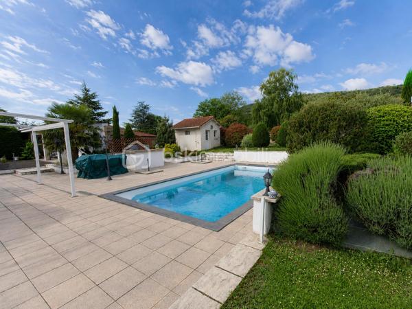 Construite en 1966 sur une belle parcelle close et arborée de 1 935 m², cette maison traditionnelle aux beaux volumes saura séduire les familles en quête d’espace, de confort et de tranquillité.

Dès l’arrivée, vous découvrirez un environnement agréable et verdoyant, sublimé par des extérieurs soigneusement aménagés avec piscine (8X4), pool house et vaste terrasse propice aux moments de convivialité.

Le rez-de-chaussée accueille un grand espace de réception avec coin bar et espace détente équipé d’un point d’eau, idéal pour recevoir famille et amis dans une ambiance conviviale. Cet espace donne directement accès à la terrasse et aux extérieurs. En demi-niveau et demi sous-sol, la maison dispose également d’une chambre avec salle d’eau, d’un WC séparé, d’une buanderie ainsi que de plusieurs espaces de rangement.

À l’étage, un couloir dessert une cuisine indépendante aménagée et équipée, un séjour lumineux, trois chambres, une salle de bain, un WC séparé ainsi que de nombreux placards et penderies.

Le chauffage est assuré par des radiateurs électriques complétés par le poêle à granulés installé dans l’espace de vie du rez-de-chaussée.

Côté annexes, le bien bénéficie d’un double garage avec cave à l’arrière, d’un atelier attenant à la maison et de combles perdus au-dessus.

Cette propriété offre un fort potentiel pour accueillir une grande famille, recevoir des proches ou simplement profiter d’un cadre de vie privilégié avec de beaux espaces intérieurs et extérieurs.

Un bien rare sur le secteur, alliant charme, fonctionnalité et qualité de vie.