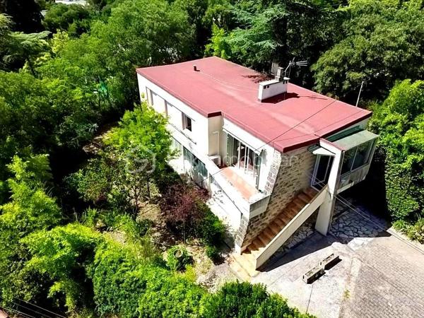 Dans le secteur résidentiel Route de Sauve - Valdegour, découvrez cette maison individuelle R+1 de 86 m² habitables, implantée sur une jolie parcelle arborée de 860 m².

À l'étage, l'habitation se compose d'un salon-séjour lumineux exposé Sud-Ouest, d'une cuisine indépendante, de 4 chambres, d'une salle de bains et d'un WC séparé.
Le rez-de-chaussée offre un véritable atout avec un garage ainsi que des pièces aménagées d'une superficie totale de plus de 40 m². Cet espace d'une hauteur sous plafond entre de 2 m à 2.15 m pourra facilement répondre à vos besoins : bureau, salle de jeux, salle de sport, spa, atelier ou espace de réception.
Côté confort, la maison bénéficie de la climatisation réversible, de menuiseries PVC double vitrage, de volets roulants électriques et d'une toiture isolée.

À l’extérieur, vous découvrirez un jardin verdoyant, agrémenté de grands arbres matures qui préservent l’intimité de la propriété en la protégeant de tout vis-à-vis. Au fond du terrain se cache un espace intimiste et préservé, surnommé « le Nid d'Amour ». Le terrain, entièrement situé en zone urbaine, permet également d'envisager différents projets tels qu'une piscine, une extension ou une dépendance.   
Stationnement de plusieurs véhicules sur la parcelle.

La façade principale, réalisée en authentique pierre du Pont du Gard, confère à la propriété un cachet rare et intemporel. 

Travaux de rafraîchissement importants à prévoir, notamment la mise en conformité de l'installation électrique, la modernisation de la cuisine ainsi que de la salle de bain.

Taxe foncière : 1 502 €/an

Propriété proche des transports, écoles et commerces, pleine de potentiels,
Une belle opportunité pour les familles à la recherche d'espace, de verdure et d'un bien à personnaliser selon leurs envies.

À visiter sans tarder !