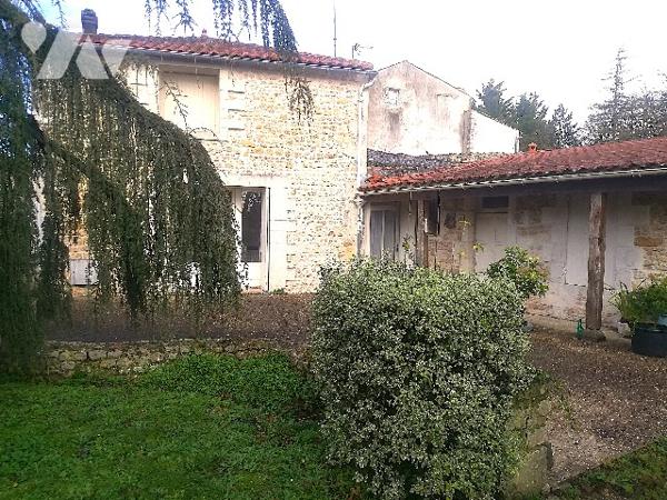 En centre-bourg, jolie maison ancienne avec partie appartement, garages et jardin d'agrément clos