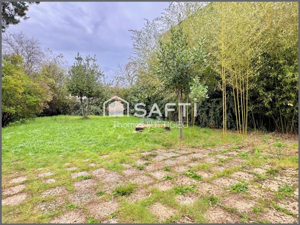 Maison de ville avec garage et jardin.