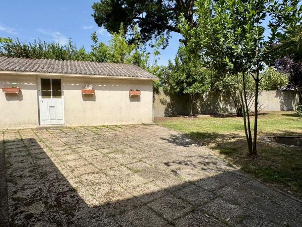 Maison de ville avec garage et jardin.