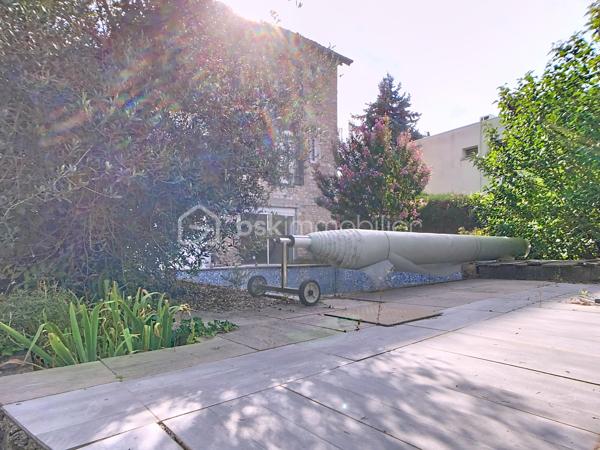 Édifiée sur un terrain de plus de 790 m², venez découvrir cette charmante maison de pierre qui saura vous séduire par son style, son potentiel, son jardin arboré et sa piscine. 
Dès le pas de la porte franchi, la double exposition permet à la luminosité de vous envelopper. Face à vous le séjour, sur votre gauche la salle à manger avec sa cuisine ouverte vous invite à la convivialité. Sur  votre droite, une chambre avec sa salle d'eau vous permet de bénéficier d'une chambre au rez-de-chaussée. Vous trouverez également un wc à ce niveau. A l'étage vous trouverez 2 chambres et une salle d'eau avec wc desservies par un palier. Au-dessus d'une des chambres se situe une quatrième pièce pouvant servir de chambre, de bureau, de salle de jeux. Au rez de chaussée côté jardin vous aurez la chance de découvrir deux chambres lumineuses avec vue sur la piscine. Une salle de bains avec douche et baignoire agrémente ce niveau.
Côté technique, la maison possède des huisseries en pvc, des volets roulants électriques, une alarme, la fibre, un portail électrique, une climatisation réversible, un chauffage au gaz de ville, et un forage pour l'eau. 
Côté jardin, outre la multitude d'essence différente entre arbres fruitiers, olivier et un majestueux  cèdre, vous bénéficierez d'un espace barbecue près de la piscine en dur,  d'un atelier et d'une serre. 
En venant visiter, vous comprendrez aisément que cette maison atypique, n'est pas la maison de Mme ou Mr tout le monde. Elle est unique, surprenante, chaleureuse, comme vous, non ?
