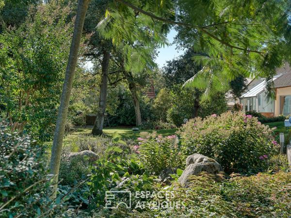 Maison familiale avec jardin arboré et piscine intérieure.