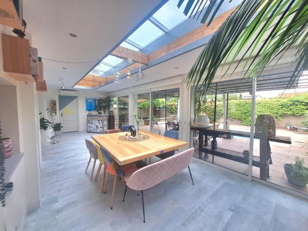 Charmante maison familiale, avec une pièce de vie chaleureuse au volume généreux, ouverte sur une véranda chauffée, véritable continuité avec la terrasse extérieure.