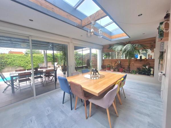 Charmante maison familiale, avec une pièce de vie chaleureuse au volume généreux, ouverte sur une véranda chauffée, véritable continuité avec la terrasse extérieure.