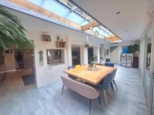 Charmante maison familiale, avec une pièce de vie chaleureuse au volume généreux, ouverte sur une véranda chauffée, véritable continuité avec la terrasse extérieure.