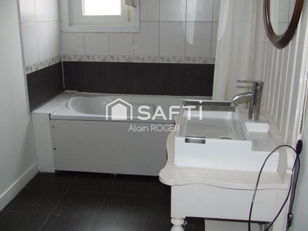 Maison de ville avec garage et terrasse.