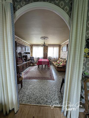 Maison de plain-pied des années 60 à rénover sur un terrain clos de 800 m² et double garage.