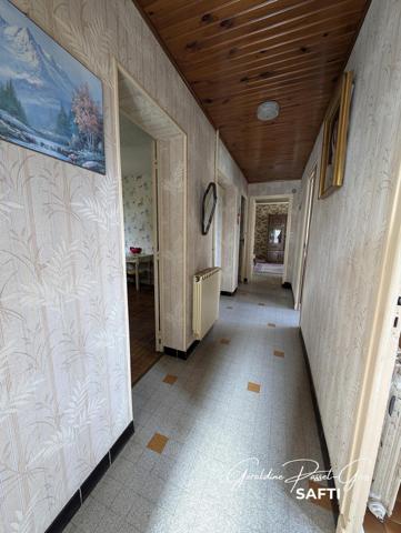 Maison de plain-pied des années 60 à rénover sur un terrain clos de 800 m² et double garage.
