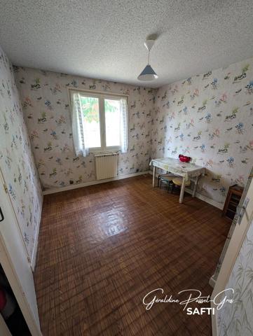 Maison de plain-pied des années 60 à rénover sur un terrain clos de 800 m² et double garage.