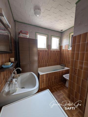 Maison de plain-pied des années 60 à rénover sur un terrain clos de 800 m² et double garage.
