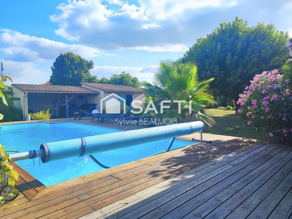 Propriété en pierre avec piscine et jardin arboré.