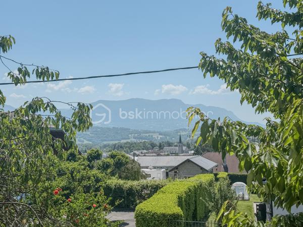 Sur les premières hauteurs d’Albens, au sein de la commune d’Entrelacs et à proximité des commodités accessibles à pied, découvrez cette maison de 1968 offrant un fort potentiel d’aménagement dans un environnement agréable avec vue montagne.

Édifiée sur une parcelle d’environ 757 m², cette bâtisse développe près de 160 m² habitables complétés par un sous-sol complet comprenant garage, cave, chaufferie et WC.

Aujourd’hui organisée en deux espaces de vie distincts, la maison offre une configuration particulièrement intéressante pour différents projets : grande maison familiale, habitat intergénérationnel ou encore résidence principale avec espace indépendant pouvant accueillir un petit projet locatif.

Le premier niveau propose un séjour/ salle à manger avec accès à un balcon filant bénéficiant d’une agréable vue dégagée sur les montagnes, une cuisine indépendante, deux chambres, une salle d’eau ainsi qu’un WC séparé.

À l’étage, un second espace de vie se compose d’un salon avec cuisine ouverte, d’une chambre, d’une grande pièce pouvant accueillir une quatrième chambre ou un vaste salon, ainsi qu’une salle de bain et un WC indépendant.

À l’extérieur, vous profiterez d’un terrain agréable d’environ 757 m², d’une grande terrasse et de possibilités de stationnement, dans un cadre résidentiel recherché permettant de profiter pleinement de la vie de commune tout en restant proche des services.

Entièrement à rénover, cette maison s’adresse aux acquéreurs en quête d’un bien à façonner selon leurs envies et leurs besoins, avec l’opportunité rare de créer un lieu de vie sur mesure dans un secteur apprécié d’Entrelacs.