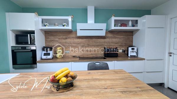 Réf. Ludivine - Située dans un environnement résidentiel paisible, découvrez cette magnifique maison contemporaine de plain-pied (construction 2010) de 135 m². Particulièrement soignée et élégante, elle se distingue par son excellent classement énergétique DPE B et des prestations de qualité. Ici, pas de travaux à prévoir : posez simplement vos valises et profitez d'un confort de vie optimal avec des charges courantes maîtrisées.
FACTURES D'ÉNERGIE MINIMISÉES & ÉQUIPEMENTS RÉCENTS
- Panneaux solaires en autoconsommation (octobre 2022) + Chauffe-eau thermodynamique (2023).
- Poêle à granulés performant (2016, conduit 2025) idéalement installé au centre de la maison
- Excellente isolation globale. Menuiseries double vitrage PVC/Alu avec volets roulants motorisés, isolation des combles (2026).
DES ESPACES FONCTIONNELS
- La Pièce de Vie (70 m²) : Un vaste volume central lumineux et traversant, ouvrant directement sur les deux terrasses à l'avant et l'arrière de la maison. La cuisine américaine haut de gamme entièrement équipée dispose d'un cellier attenant.
L’Espace Nuit & Travail :
- 2 belles chambres (12 m² et 17 m²) avec parquet, dont une avec un grand dressing intégré.
- 1 bureau, une chambre d'enfant ou autre.
- 1 salle d'eau contemporaine avec meuble double vasque et douche cabine/baignoire.
- Technique : Électricité aux normes, VMC, assainissement collectif.
UN EXTÉRIEUR CLOS, PAYSAGER
- Côté Détente : À l'arrière, profitez d'une grande terrasse de 50 m² à l'abri des regards, équipée de deux stores bannes motorisés, accueillant un espace jacuzzi.
- Le jardin d'environ 1700 m² est entièrement clôturé et paysager (parterres fleuris, bel olivier, beaux aménagements). Une borne ASA (eau du Lot) vous permet d'arroser vos extérieurs à moindre coût.
Un garage de 35 m² avec porte sectionnelle isolée et motorisée complète l'ensemble. L'avant de la maison est impeccable avec un grand parking, accessible par un portail coulissant suspendu et motorisé (2021). De petites dépendances en bois vous permettront de stocker votre petit outillage ou d'hiverner le mobilier de jardin.
ON AIME : 
- DPE B : Une maison économe, Zéro budget travaux et des équipements récents : Cuisine (2021), portail (2021), panneaux solaires (2022), cumulus (2023), isolation des combles (2026), enrobé.
Et si *Ludivine* était votre nouvelle maison ? Contactez-moi pour planifier une visite rapidement !