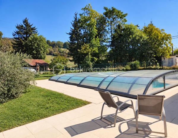 À Cranves-Sales, à 4 minutes de l'A40, dans un environnement résidentiel agréable et à proximité de Genève et de la frontière suisse, découvrez cette maison familiale offrant de beaux volumes, de très agréables extérieurs et de nombreux espaces pour profiter de la maison en toute saison.

Implantée sur un terrain plat, clos et arboré d’environ 1 600 m², accessible par un portail électrique, la propriété bénéficie d’un cadre verdoyant agrémenté de plusieurs arbres fruitiers : figuier, prunier, pommier…

La maison dispose actuellement de 108 m² habitables officiels au premier étage, auxquels s’ajoutent environ 42 m² aménagés au rez-de-chaussée.
Ces espaces aménagés au rez-de-chaussée font actuellement l’objet d’une démarche de régularisation administrative auprès de la mairie.

Le premier étage accueille les principales pièces de vie et bénéficie d’une belle luminosité grâce à son exposition sud.

Il se compose de 3 chambres, d’un salon-salle à manger lumineux exposé plein sud, d’une cuisine séparée, également orientée sud, ainsi que d’une salle de bains avec douche, WC et meuble double vasque.

Un grand balcon exposé sud prolonge agréablement les pièces de vie et permet de profiter pleinement des beaux jours.

Le rez-de-chaussée offre environ 42 m² aménagés, actuellement organisés comme une véritable suite parentale.

Elle comprend une grande chambre, un dressing, une salle de bains équipée d’une baignoire balnéo et d’un meuble double vasque contemporain, ainsi qu’un WC indépendant.

Un espace confortable qui peut également convenir pour accueillir famille ou amis, créer un espace indépendant ou simplement profiter d’un niveau supplémentaire au sein de la maison.

Ce niveau comprend également un grand garage ainsi qu’une cave, et un espace couvert extérieur offrant de précieux espaces de stationnement et de rangement.

À l’extérieur, le jardin de 1 600 m², plat, clos et arboré, offre de nombreux espaces dédiés à la détente.

La propriété dispose d’une piscine enterrée et couverte, permettant d’en profiter sur une période particulièrement étendue de l’année.

À proximité immédiate de la piscine, une petite dépendance aménagée façon bar / lounge apporte une vraie convivialité.

Une grande terrasse esprit solarium permet de profiter du soleil, l'environnement invite aux déjeuners et aux longues soirées d’été.

Le jardin, généreux et facile à vivre, laisse également de nombreuses possibilités : jeux pour les enfants, potager, détente ou simplement le plaisir d’un bel espace vert autour de la maison. Un grand espace clos ombragé permet à une famille avec des chiens par exemple de pouvoir les garder en sécurité dans la propriété même quand le portail est ouvert.

Entre son terrain de 1 600 m², sa piscine couverte, ses espaces extérieurs conviviaux, sa grande suite aménagée au rez-de-chaussée et ses pièces de vie baignées de lumière, cette maison offre un cadre particulièrement agréable pour une famille recherchant espace, confort et proximité immédiate avec Genève.

Surface habitable actuellement reconnue : 108 m²
Environ 42 m² supplémentaires aménagés au rez-de-chaussée, faisant actuellement l’objet d’une démarche de régularisation administrative auprès de la mairie.
Terrain : environ 1 600 m², plat, clos et arboré.
Piscine enterrée et couverte – grand garage – cave – portail électrique.