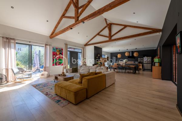 De l’espace pour recevoir, un patio pour s’isoler, une piscine pour profiter des beaux jours… À proximité immédiate du centre-ville de Roanne, cette maison de ville à l’esprit loft conjugue volumes remarquables et douceur de vivre, au calme, en retrait des axes passants.

Réhabilitée en 2021, elle développe environ une surface habitable de 224 m² habitables (surface carrez : 199 m²), sur un terrain clos et arboré de 746 m². Poutres apparentes, belles hauteurs sous plafond et larges ouvertures soulignent le caractère des lieux.

Au cœur de la maison, une pièce de vie d’environ 110 m² réunit cuisine équipée avec îlot central, espace repas et vaste salon. 

Ouverte sur le jardin et la piscine d’un côté, sur le patio intérieur de l’autre, elle invite à vivre autant dedans que dehors.

Le rez-de-chaussée accueille deux chambres donnant sur le patio, dont une suite parentale avec dressing et salle d’eau, ainsi qu’une buanderie et un WC indépendant.

À l’étage, une chambre, une salle de bains avec WC et une seconde pièce disposant d’un point d’eau et d’un WC permettent d’adapter les espaces à vos besoins : quatrième chambre, bureau ou salle de jeux.

À l’extérieur, terrasse, jardin et piscine au sel de 7 × 4 m composent un cadre idéal pour les repas d’été et les moments en famille. Un double carport avec espace de stockage à l’étage complète l’ensemble.

Classée A au DPE, la maison bénéficie d’une pompe à chaleur air/eau, d’un chauffage au sol, de menuiseries à double vitrage renforcé et d’un portail motorisé.

À proximité des écoles, des commerces et de la gare, une maison pour ceux qui souhaitent profiter de la ville tout en conservant de l’espace et un véritable extérieur.
